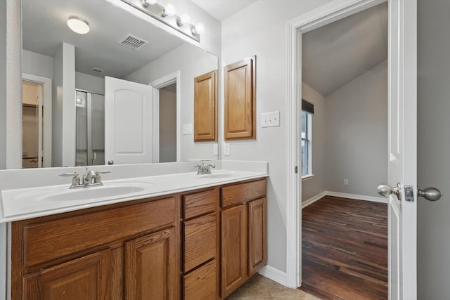full bath featuring a sink, double vanity, baseboards, and visible vents