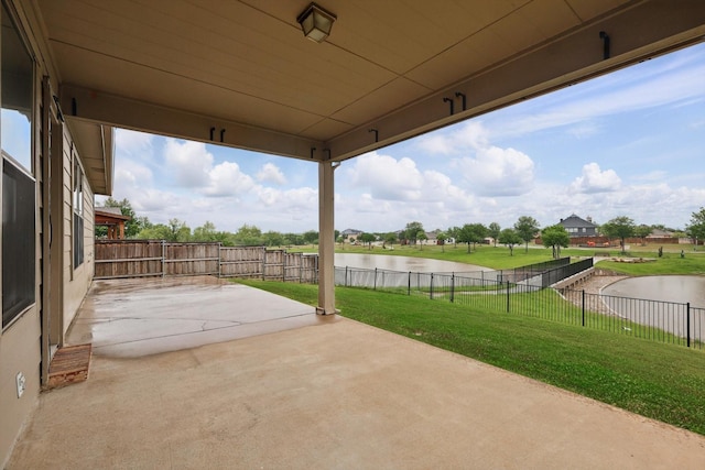 view of patio / terrace featuring a water view and a fenced backyard