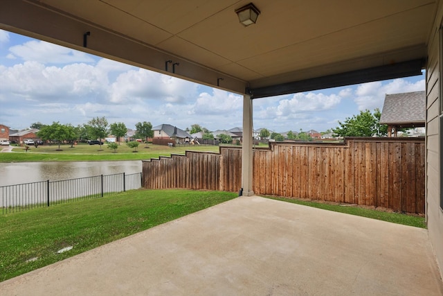 view of patio / terrace featuring a water view, a residential view, and a fenced backyard
