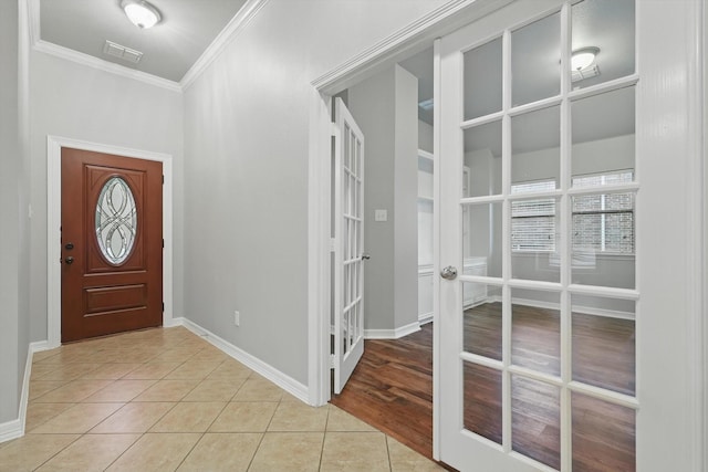 entrance foyer with french doors, light tile patterned floors, baseboards, ornamental molding, and visible vents