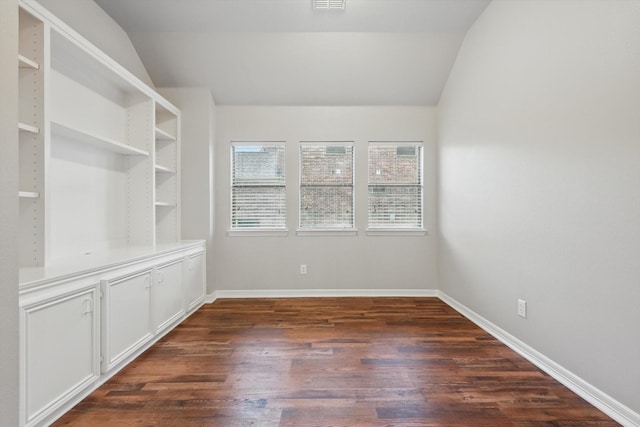 empty room featuring vaulted ceiling, baseboards, dark wood-type flooring, and visible vents