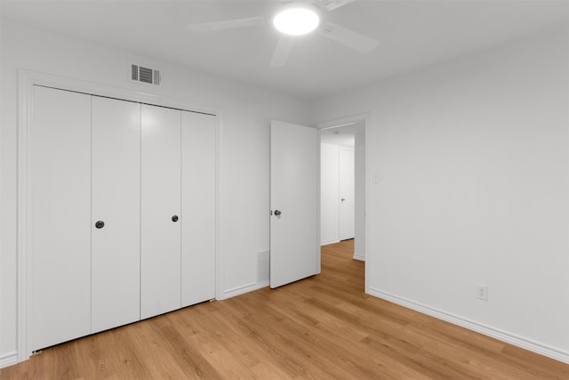 unfurnished bedroom featuring light wood finished floors, a closet, baseboards, and a ceiling fan