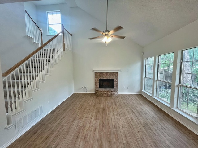 7636 Arbor Ridge Ct, Fort Worth, TX 76112 - unfurnished living room featuring a ceiling fan, a brick fireplace, stairway, and wood finished floors
