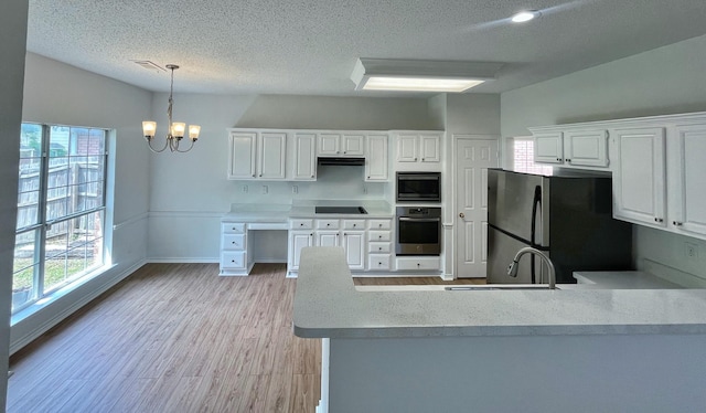 7636 Arbor Ridge Ct, Fort Worth, TX 76112 - kitchen featuring an inviting chandelier, a sink, a peninsula, stainless steel appliances, and white cabinets