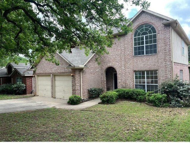 7636 Arbor Ridge Ct, Fort Worth, TX 76112 - traditional home with concrete driveway, brick siding, a front yard, and a garage