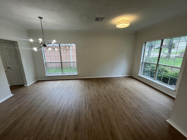 7636 Arbor Ridge Ct, Fort Worth, TX 76112 - unfurnished dining area with an inviting chandelier, dark wood finished floors, visible vents, and a textured ceiling