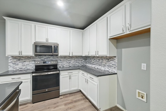 kitchen featuring white cabinetry, backsplash, dark countertops, and appliances with stainless steel finishes