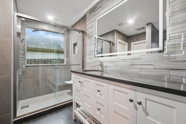 full bath with tile patterned floors, vanity, visible vents, and a stall shower