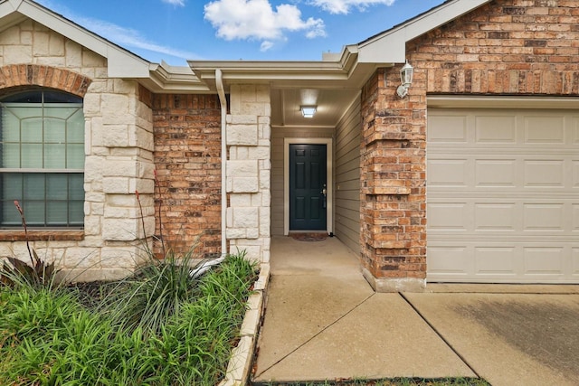 property entrance with stone siding, brick siding, and a garage
