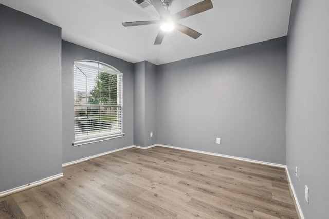 spare room featuring ceiling fan, baseboards, and wood finished floors