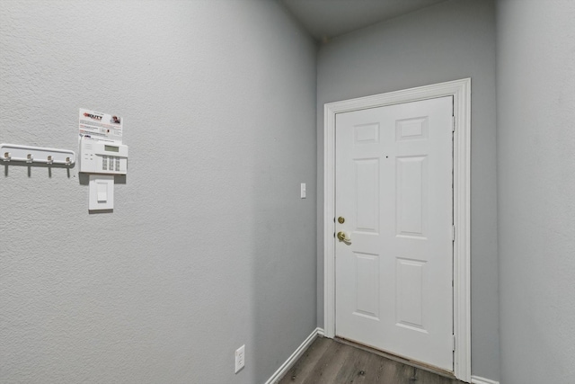 doorway to outside with dark wood-style flooring and baseboards