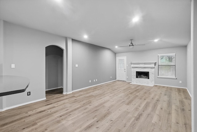 unfurnished living room featuring arched walkways, recessed lighting, light wood-type flooring, and ceiling fan