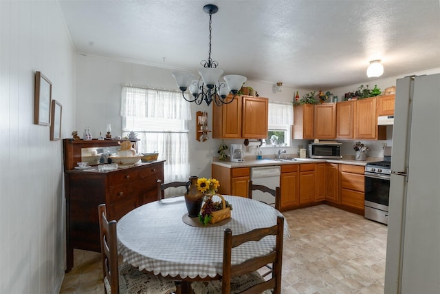 6111 County Road 2610, Bonham, TX 75418 - kitchen with under cabinet range hood, light countertops, appliances with stainless steel finishes, and an inviting chandelier
