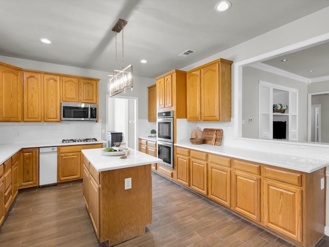 6330 Dublin Dr, Garland, TX 75044 - kitchen with appliances with stainless steel finishes, light countertops, decorative backsplash, a center island, and dark wood-style flooring