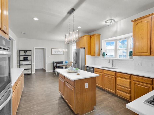 6330 Dublin Dr, Garland, TX 75044 - kitchen with a sink, stainless steel appliances, a kitchen island, dark wood-type flooring, and light countertops