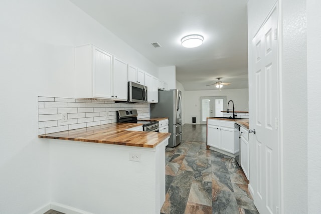108 Freedom Trl, Forney, TX 75126 - kitchen with a sink, a peninsula, stainless steel appliances, wood counters, and stone finish flooring