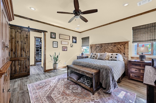 650 Scoggins Rd, Tioga, TX 76271 - bedroom featuring a barn door, wood finished floors, baseboards, multiple windows, and crown molding