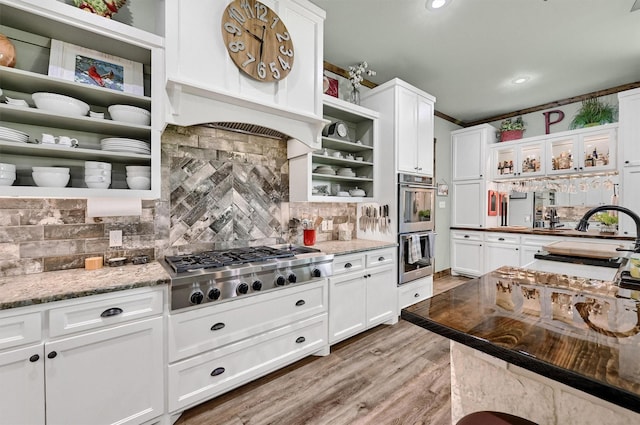 650 Scoggins Rd, Tioga, TX 76271 - kitchen with open shelves, stainless steel appliances, white cabinets, tasteful backsplash, and light wood finished floors