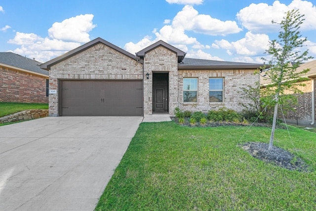view of front of home featuring concrete driveway, a front yard, brick siding, and a garage