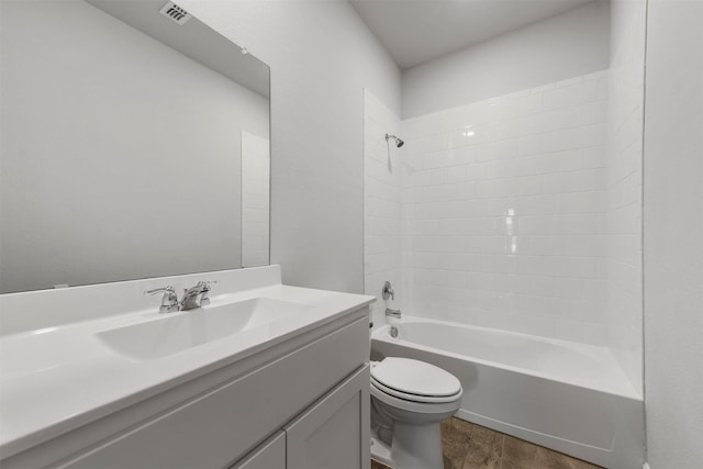 bathroom featuring toilet, wood finished floors, visible vents, vanity, and shower / bathtub combination