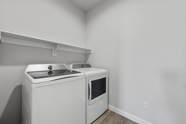 laundry room with washer and dryer, laundry area, wood finished floors, and baseboards