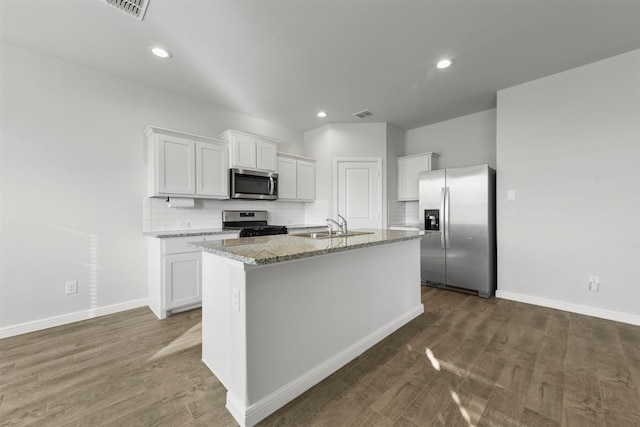 kitchen featuring a sink, stainless steel appliances, visible vents, a center island with sink, and white cabinets