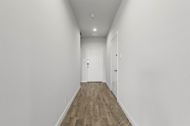 hallway with wood finished floors, baseboards, and recessed lighting