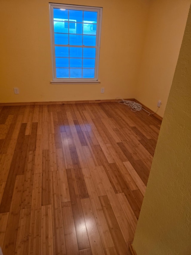1608 University Dr, Richardson, TX 75081 - empty room featuring wood-type flooring and baseboards