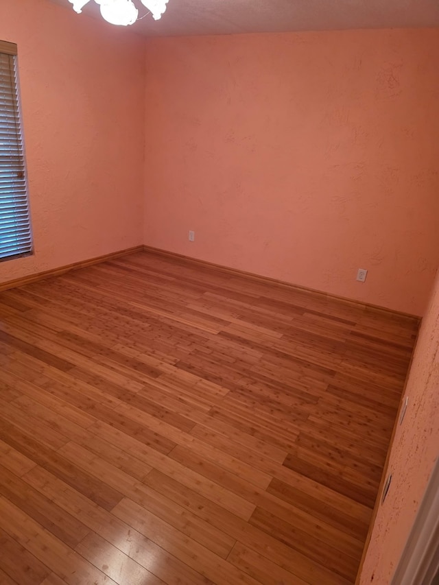 1608 University Dr, Richardson, TX 75081 - empty room with hardwood / wood-style flooring and a chandelier