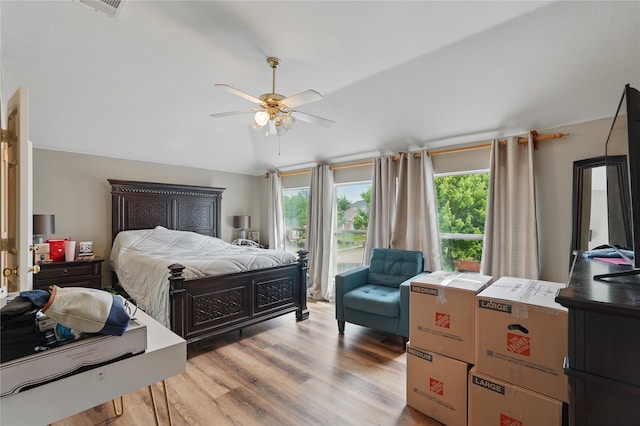bedroom with ceiling fan, access to outside, and wood finished floors