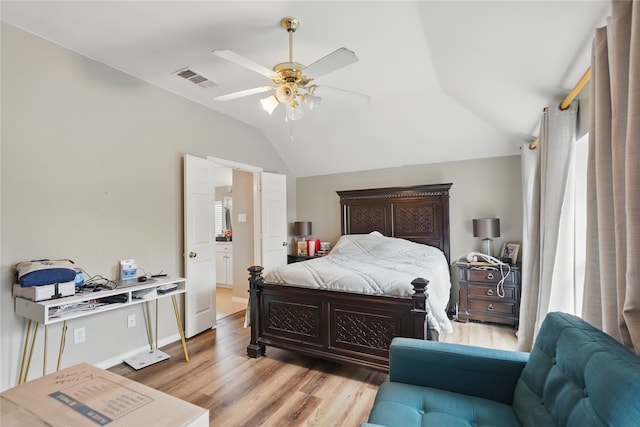 bedroom with vaulted ceiling, light wood-type flooring, visible vents, and a ceiling fan