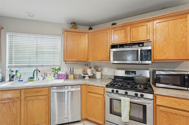 kitchen with light countertops, appliances with stainless steel finishes, and a sink