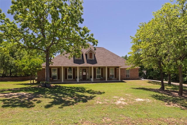 rear view of property featuring a yard, a porch, and roof with shingles