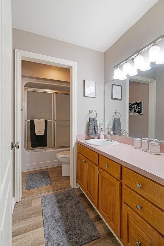 425 County Road 32230, Sumner, TX 75486 - bathroom with vanity, toilet, combined bath / shower with glass door, and wood finished floors