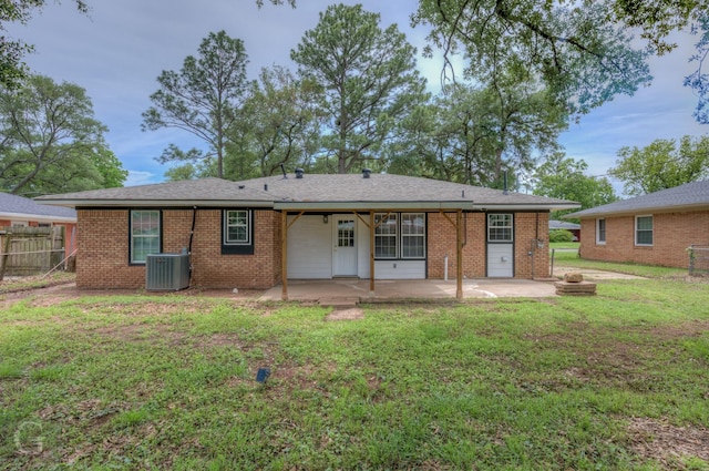 rear view of property with a patio area, fence, brick siding, a lawn, and central AC unit