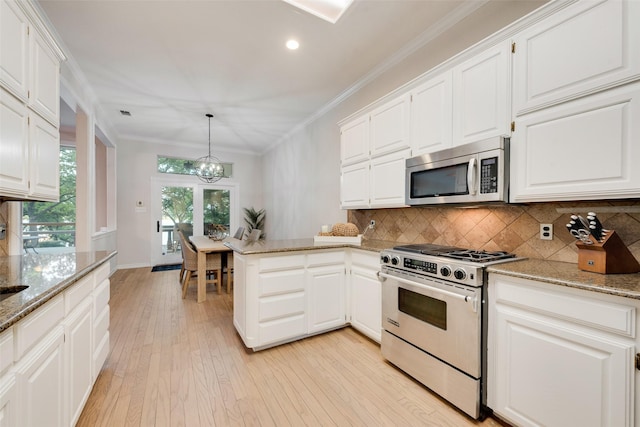 kitchen featuring stainless steel appliances, recessed lighting, light wood-style flooring, decorative backsplash, and a notable chandelier