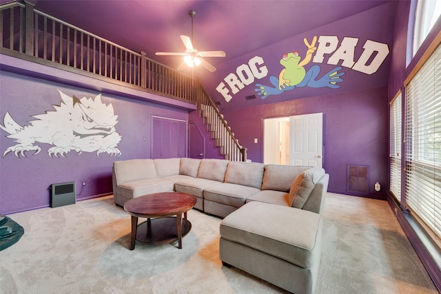 living room featuring visible vents, vaulted ceiling, ceiling fan, stairway, and carpet floors