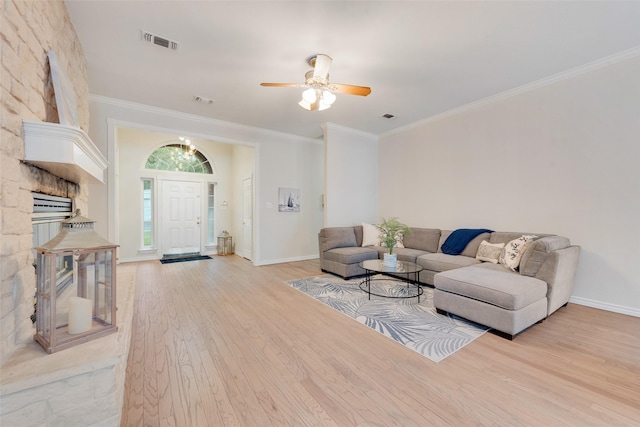 living room featuring baseboards, crown molding, light wood-style flooring, and visible vents