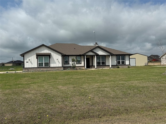 view of front of property featuring board and batten siding, roof with shingles, and a front lawn