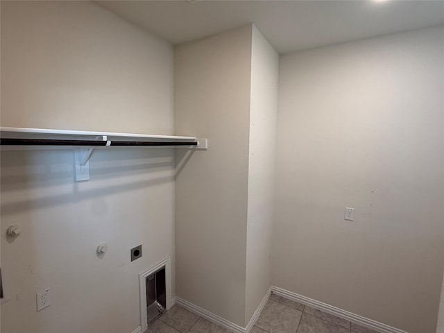 laundry area featuring laundry area, electric dryer hookup, baseboards, and light tile patterned floors