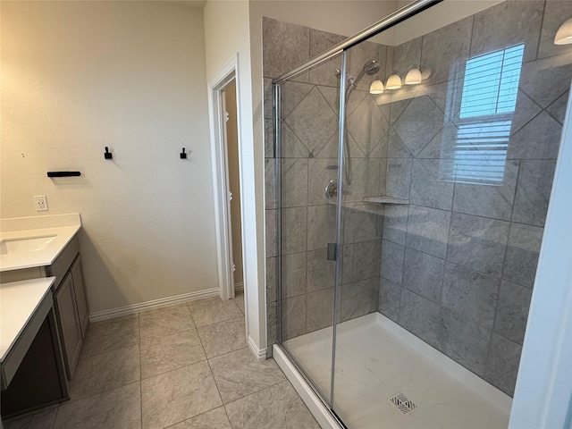 full bath with tile patterned floors, vanity, baseboards, and a stall shower
