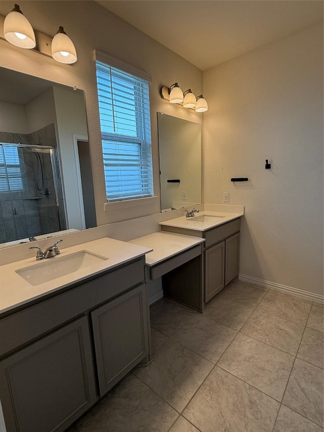bathroom featuring tile patterned flooring, a shower stall, two vanities, and a sink