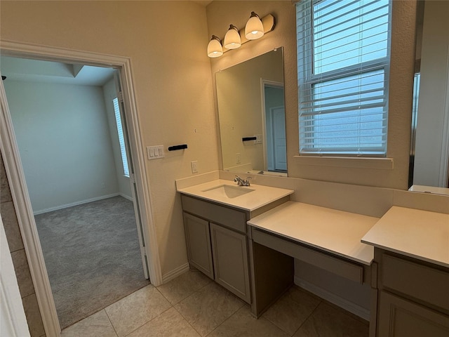 bathroom with vanity, baseboards, and tile patterned floors