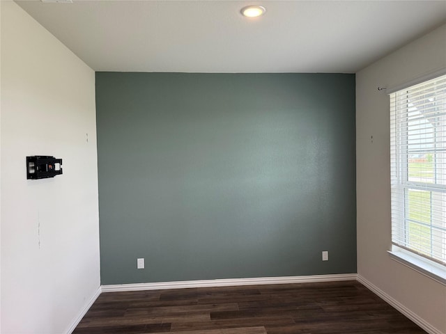 empty room featuring baseboards, dark wood-style flooring, and recessed lighting