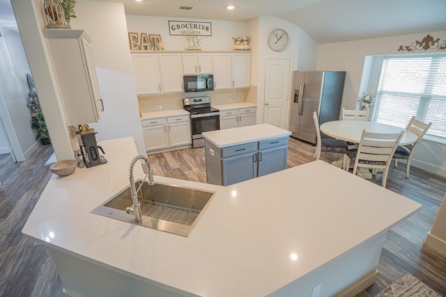 1025 N Churchill Dr, Fate, TX 75189 - kitchen featuring appliances with stainless steel finishes, a sink, wood finished floors, light countertops, and vaulted ceiling