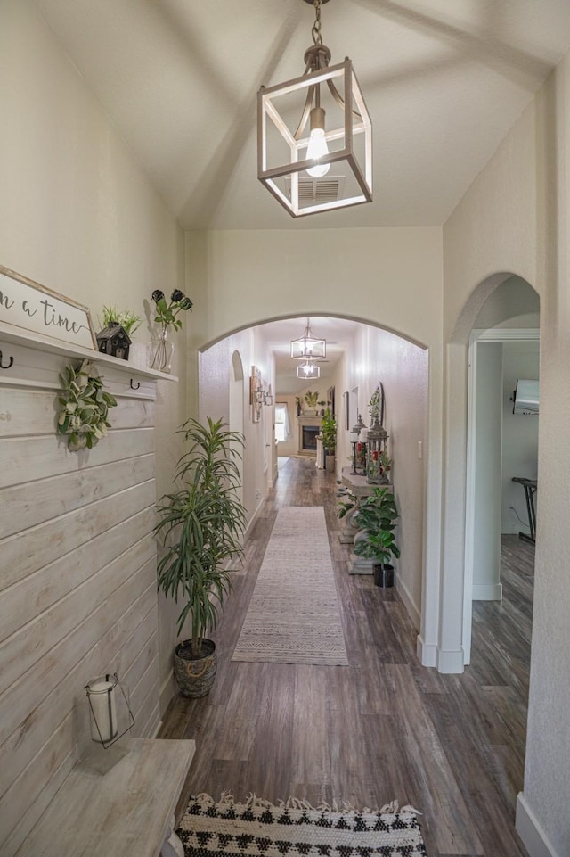 1025 N Churchill Dr, Fate, TX 75189 - hall with lofted ceiling, arched walkways, wood finished floors, a chandelier, and baseboards