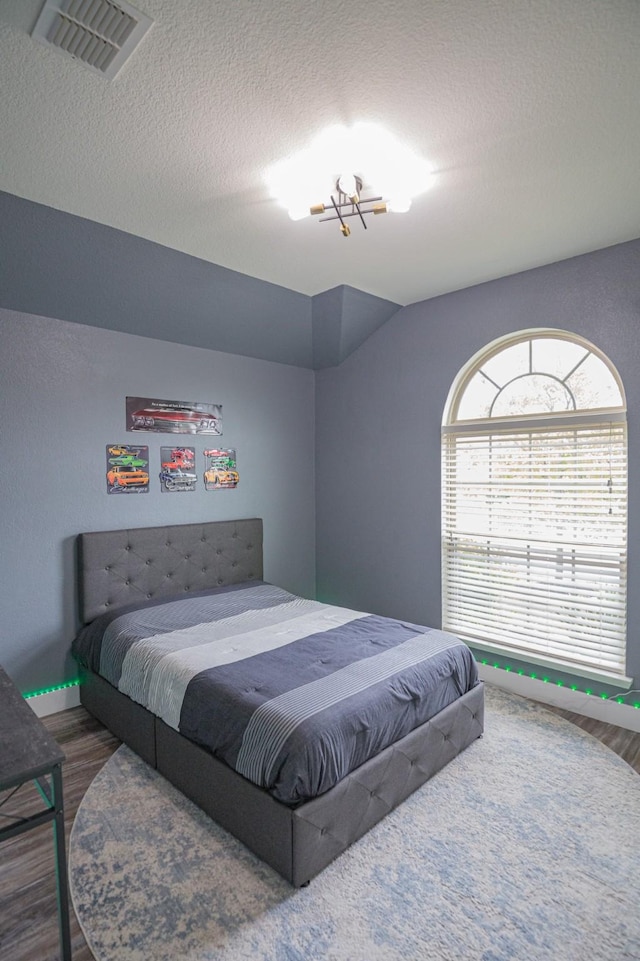 1025 N Churchill Dr, Fate, TX 75189 - bedroom featuring wood finished floors and a textured ceiling