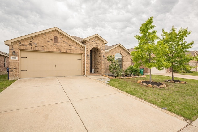 1025 N Churchill Dr, Fate, TX 75189 - view of front of home with concrete driveway, brick siding, a front lawn, and an attached garage