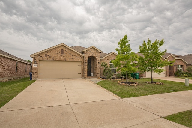 1025 N Churchill Dr, Fate, TX 75189 - view of front of house with brick siding, concrete driveway, an attached garage, and a front yard