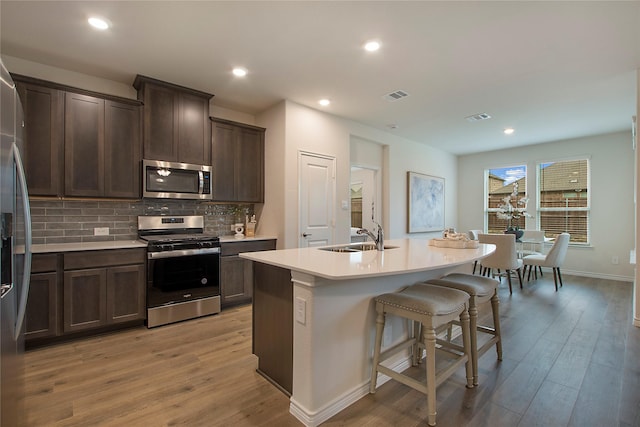 10337 Geode St, Aubrey, TX 76227 - kitchen with a sink, stainless steel appliances, light wood-style flooring, and visible vents